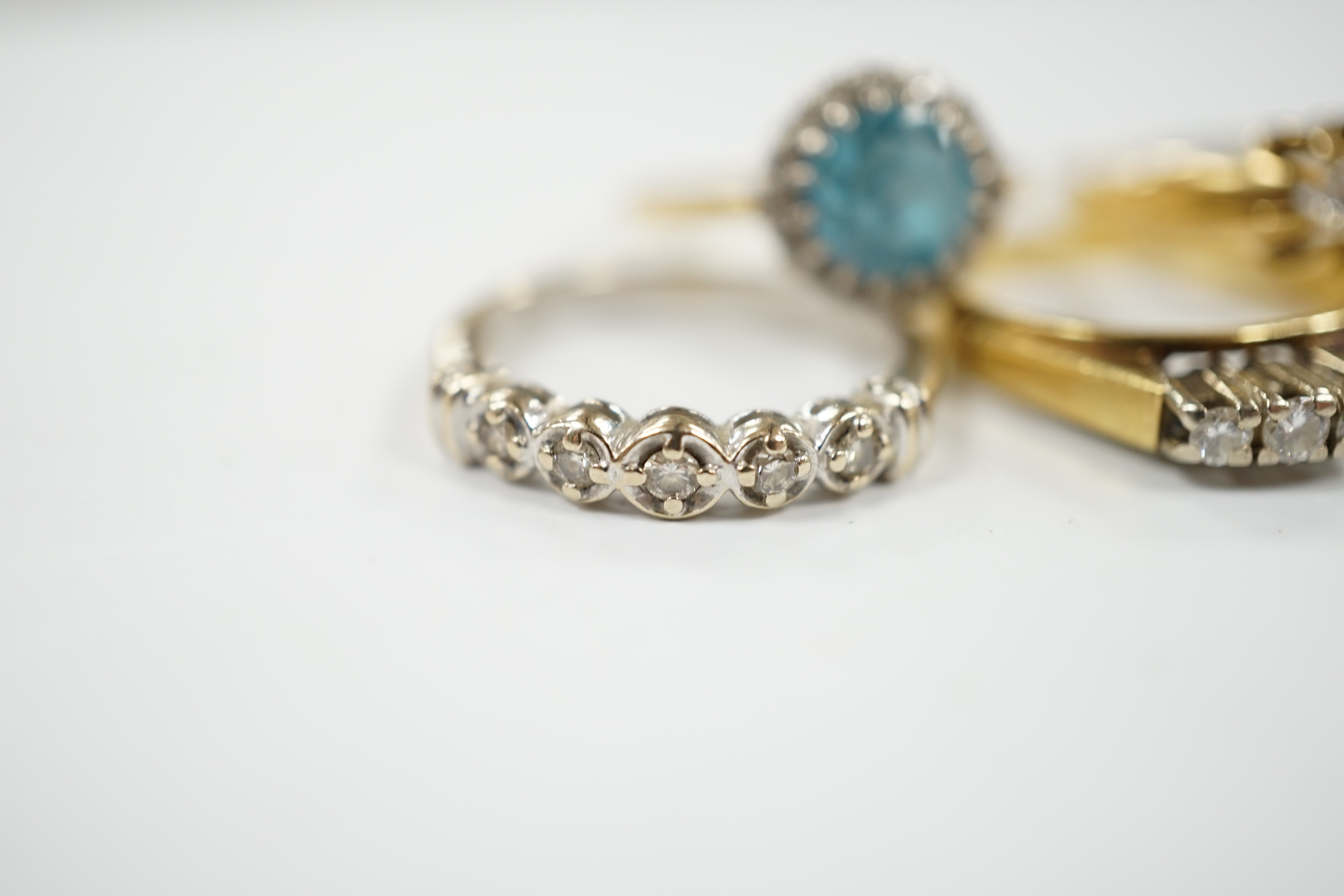 Three assorted 18ct and gem set dress rings, including blue zircon and diamond chip and claw set solitaire and one other yellow metal and gem set ring, gross weight 12.6 grams.